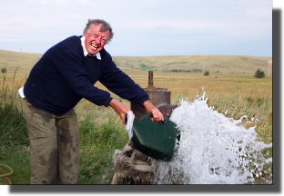 John fills up with water from a roadside "tap".